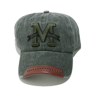 Detail of vintage washed gray cotton baseball cap with 3D M embroidery and leather patch