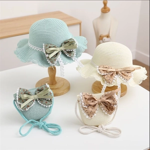Detailed straw texture of sun hat with floral bow and delicate lace trim accents
