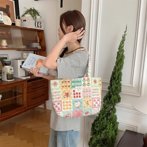 Detailed view of a quilted fabric tote bag with colorful strawberry and duck print