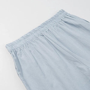 Detailed close-up of light blue elastic waistband on comfortable cotton linen trousers