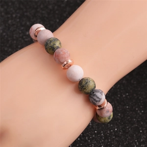 Dettaglio di un bracciale in pietra naturale da 10mm con distanziali in oro rosa al polso