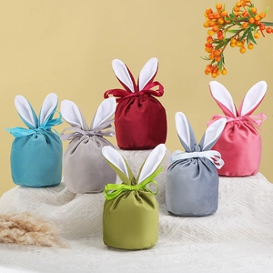 Group of velvet bunny ear gift bags with satin ribbons in various soft colors
