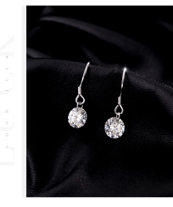 Vue macro de boucles d'oreilles en argent avec moissanite et pierres rondes étincelantes