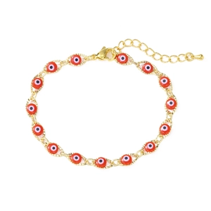 Detailed macro view of gold plated chain with red evil eye charms and lobster clasp closure