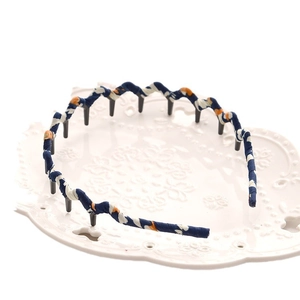 Fluffy wave fabric headband with teeth in dark blue and orange patterned fabric finish