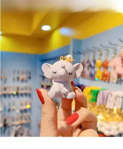 Macro detail of cute resin elephant keychain with a gold crown and pearl accent