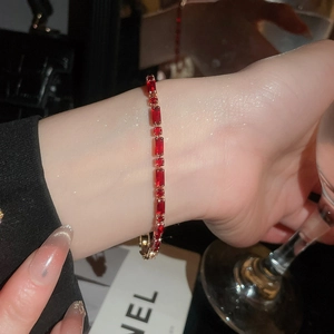 Close-up of 18k gold tennis bracelet with elegant rectangular red rubies on wrist