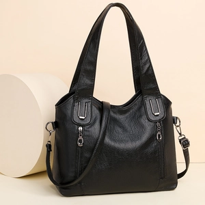 Large black textured leather tote bag with dual handles and stylish side zipper pockets