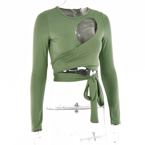 Detailansicht des grünen Crop-Tops mit Cut-out-Design und gekreuzten Taillenbändern
