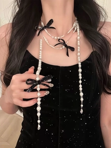 Close-up of elegant multi-layer pearl necklace with black velvet bows and crystal drops