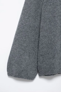 Gros plan du pull en maille grise montrant la texture épaisse et le tissage
