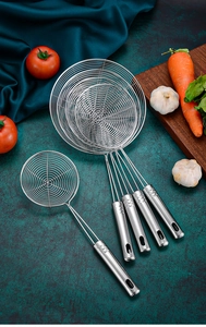 Five assorted stainless steel fine mesh skimmers with hanging hooks on a kitchen table