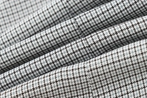 Detailed macro view of classic black and white houndstooth fabric with textured pleats