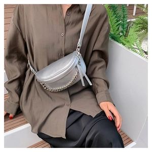 Detail of silver crossbody bag featuring litchi texture and stylish metal chain link strap