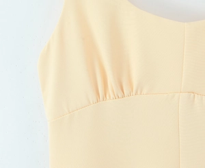 Détail de robe jaune clair élégante avec décolleté en cœur et taille plissée raffinée