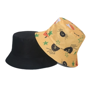 Détail de chapeaux bobs en coton avec motifs graffiti de citrouille et toile d'araignée
