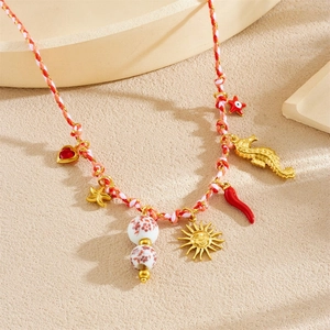 Detail of woven boho necklace with gold seahorse, starfish and colorful enamel pendants