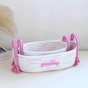 Detail of woven cotton rope storage baskets with pink goodday text and wavy stitching