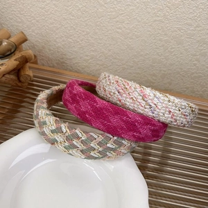 Close-up of three tweed headbands in pink and mixed colors on a white plate