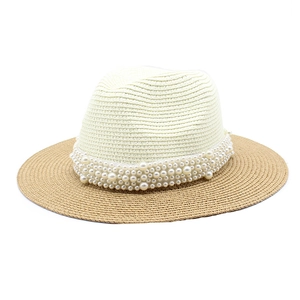 Detailed macro view of delicate faux pearls on a two-tone straw Panama fedora hat