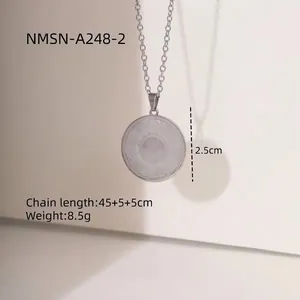 Collier en acier inoxydable argenté avec un pendentif rond texturé sur fond minimaliste