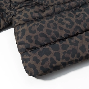 Detailed close-up of leopard print puffer jacket with quilted seams and smooth texture