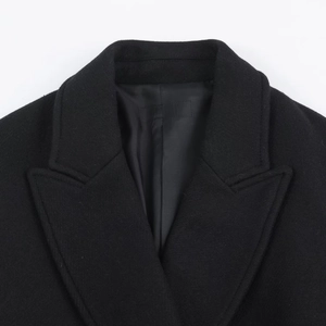 Detail view of the elegant notched lapel on a black wool blend coat for women