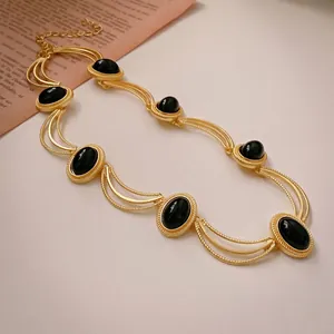 Vintage gold triple-chain necklace with oval black gemstones and ornate scrollwork borders