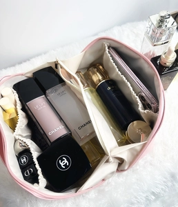 Détails d'une trousse de maquillage en cuir rose avec compartiments et élastiques