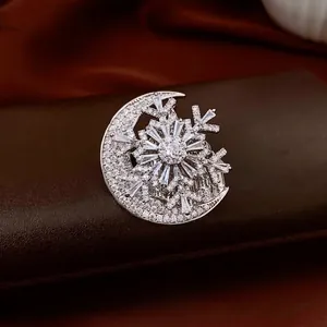 Luxury crescent moon and snowflake brooch with pave-set zircons on dark background