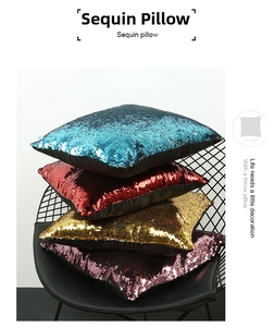 Nahaufnahme von quadratischen Paillettenkissen in Blau, Rot, Gold und Lila auf einem Stuhl