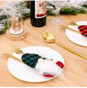 Christmas gnome cutlery holders with red and green plaid patterns on a festive table