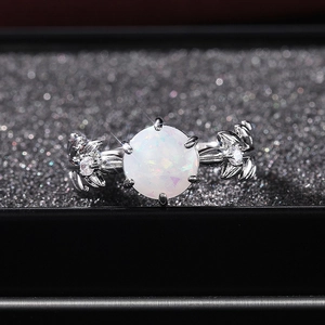 Dettaglio macro di anello a foglia in argento con opale bianco tondo e zirconi lucidi