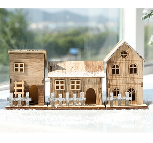 Detailed macro view of three miniature wooden Christmas houses with faux snow on windowsill