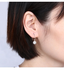 Detail of S925 silver hook earrings featuring a full crystal paved disco ball bead