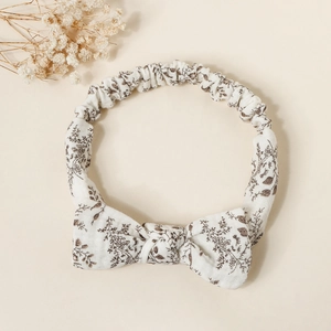 Detail of baby floral bow headband with elastic strap and vintage botanical print
