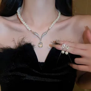 Nahaufnahme der Perlenkette mit diamantbesetzten Silberflügeln und tropfenförmigem Zirkon