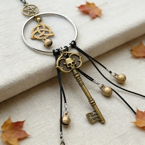 Macro detail of witchy wind chime with bronze key, pentagram charms, and bells on burlap