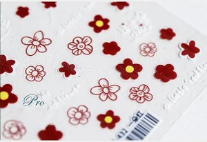 Detailed macro view of 5D embossed red and white flower nail art stickers with pro texture