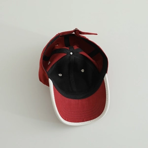 Detail view of cotton baseball cap showing internal black lining and adjustable back strap