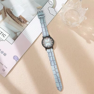 Détail du bracelet bleu clair façon crocodile et chiffres en or rose sur cadran noir