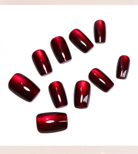 Macro display of 10-piece dark red cat eye press-on nails with magnetic shimmer effect