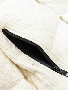 Detail of white cable knit texture featuring a high-quality black zipper pocket closure