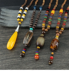 Ethnic style long necklace with wooden beads and various natural stone pendants shown close-up