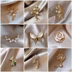 Detail of luxury alloy brooches featuring pearls, crystals, and nature-inspired motifs