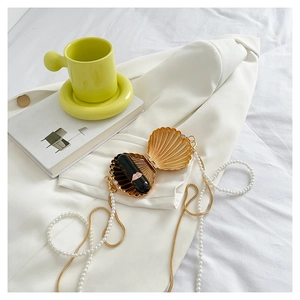 Golden shell acrylic evening bag with pearl chain strap and lipstick storage