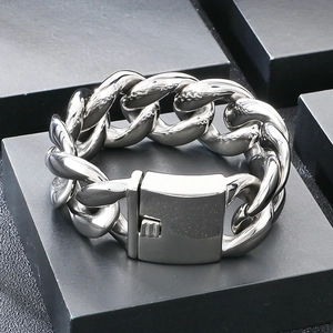 Macro detail of 30mm thick polished stainless steel Cuban link bracelet with square clasp