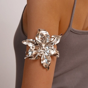 Polished silver metal arm cuff featuring a large 3D crinkled flower statement design