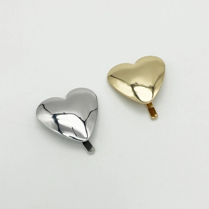 Polished metal heart hair clips in silver and gold finishes with a minimalist glossy look