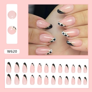 French almond press-on nails with cow print pattern and golden line accents